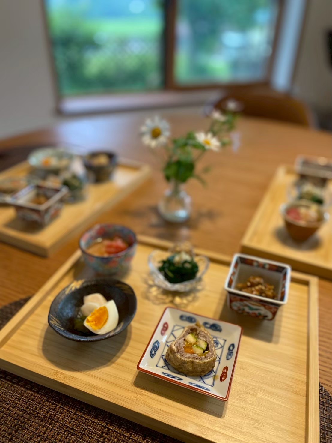 小鉢料理を木のトレーに並べた食卓